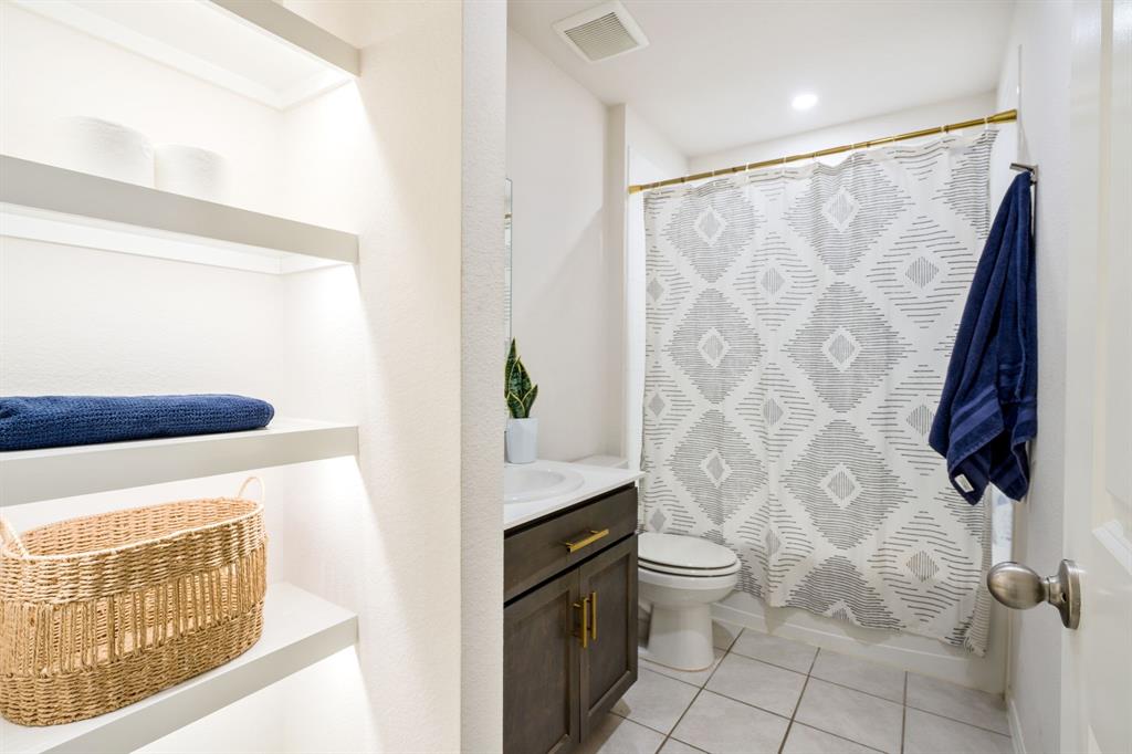 3104 Barzona Road Forney, TX 75126 - Photo 11 of 26 a bathroom with a shower curtain and a toilet