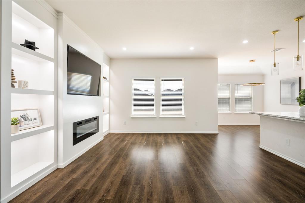 3104 Barzona Road Forney, TX 75126 - Photo 3 of 26 a view of a livingroom with a fireplace wooden floor and windows
