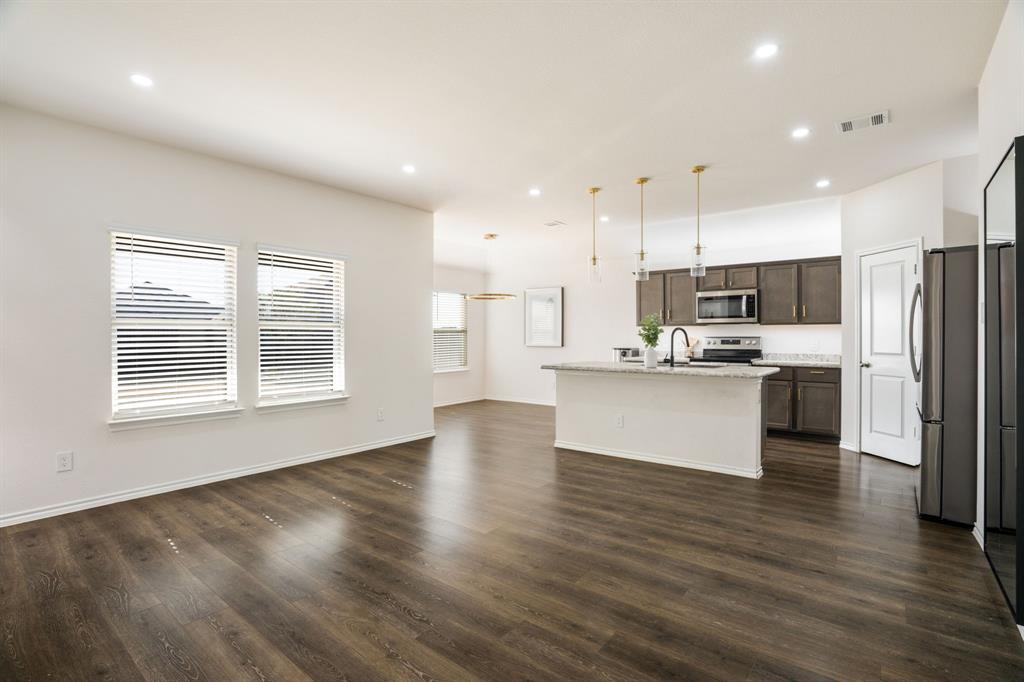 3104 Barzona Road Forney, TX 75126 - Photo 4 of 26 a view of kitchen with kitchen island wooden floor refrigerator and a sink