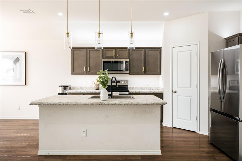 3104 Barzona Road Forney, TX 75126 - Photo 5 of 26 a kitchen with kitchen island a counter top space stainless steel appliances and wooden floor