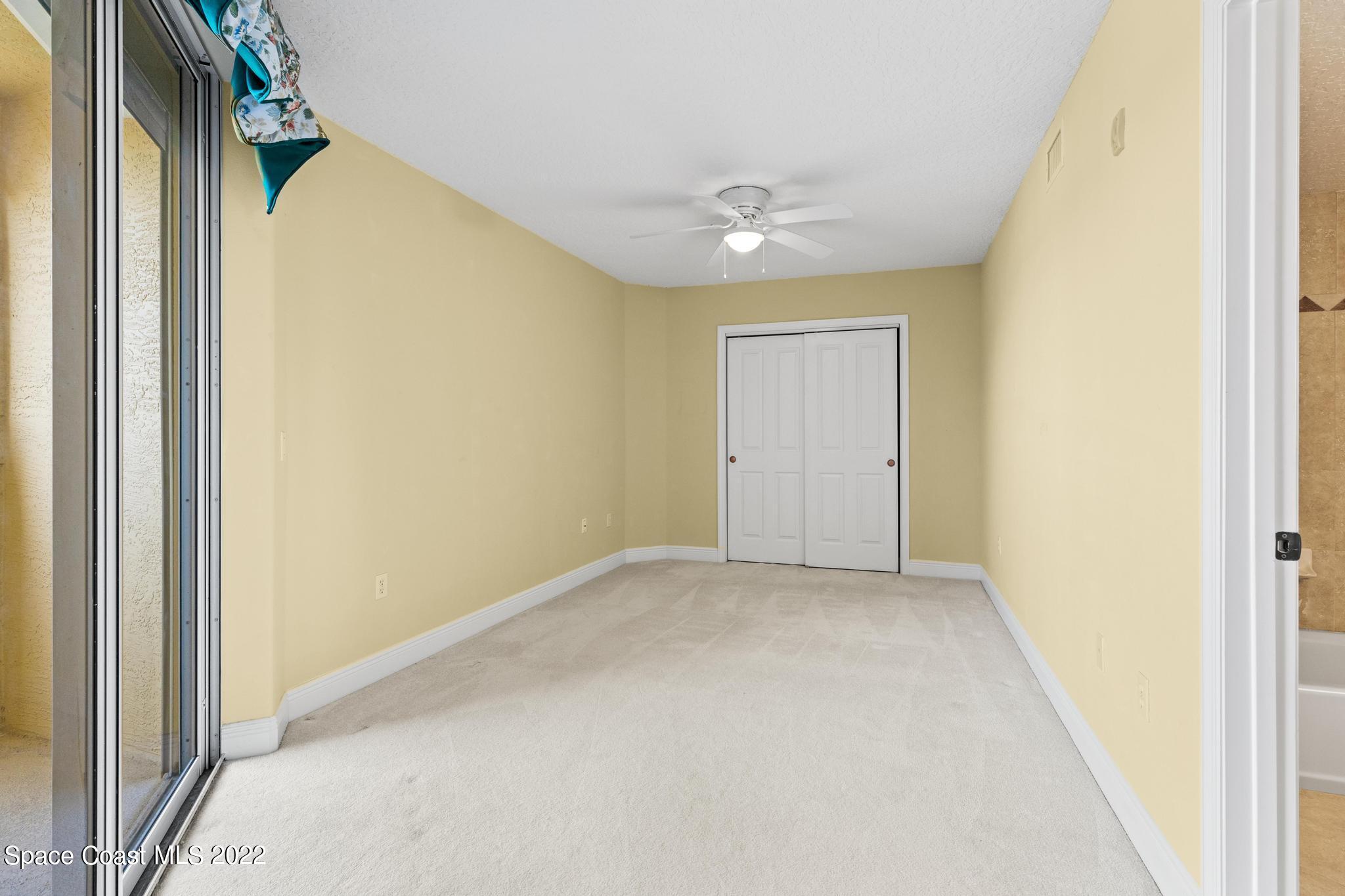 1095 Florida A1A, Unit 2301 Satellite Beach, FL 32937 - Photo 16 of 26 an empty room with a ceiling fan and a window