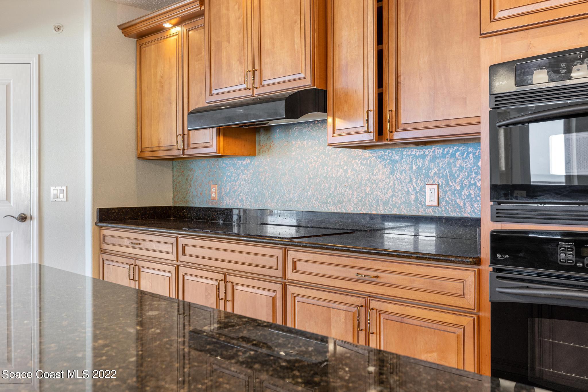 1095 Florida A1A, Unit 2301 Satellite Beach, FL 32937 - Photo 5 of 26 a kitchen with stainless steel appliances granite countertop a stove and a cabinets