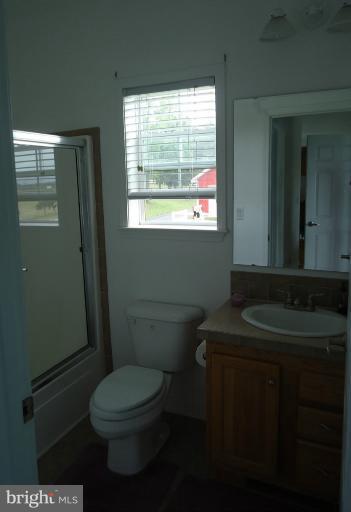 3504 Long Meadow Road Middletown, VA 22645 - Photo 1 of 28 a bathroom with a granite countertop toilet a sink and a mirror
