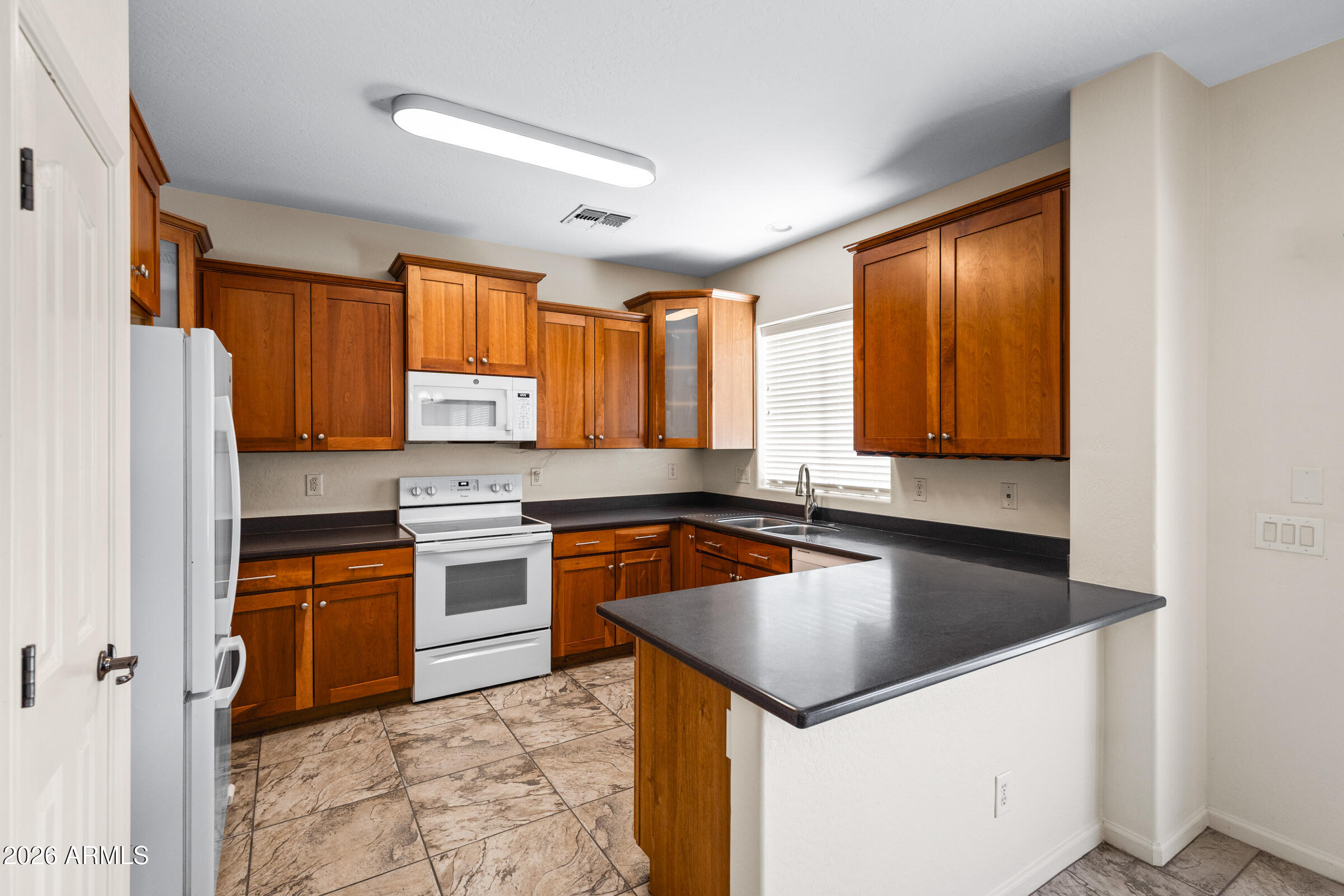 3029 East Franklin Avenue Gilbert, AZ 85295 - Photo 7 of 38 a kitchen with a stove a sink and a refrigerator