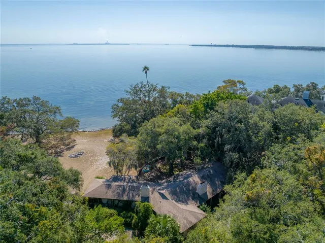 an aerial view of a house with a yard and lake view