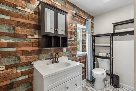 a white toilet sitting next to a bathroom sink and a shower