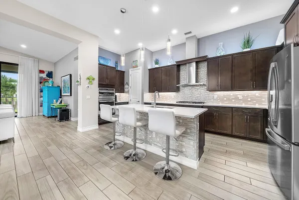 a kitchen with stainless steel appliances kitchen island granite countertop a refrigerator and a stove top oven