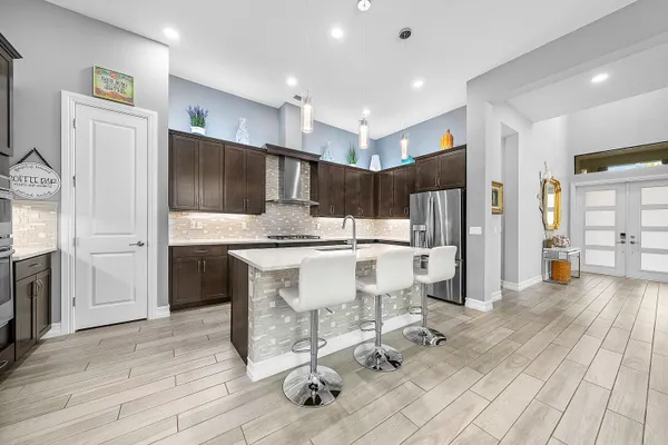 a kitchen with stainless steel appliances kitchen island granite countertop a refrigerator and a stove top oven