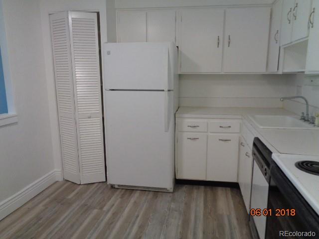 1302 South Parker Road, Unit 216 Denver, CO 80231 - Photo 2 of 13 a kitchen with a sink and a refrigerator