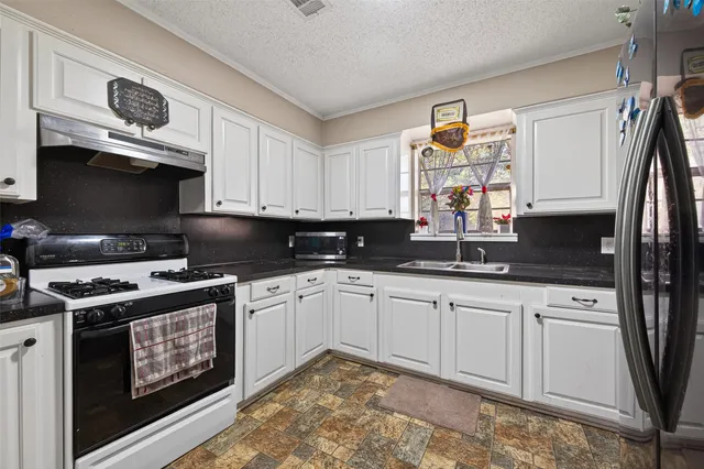 a kitchen with stainless steel appliances granite countertop a sink stove and cabinets