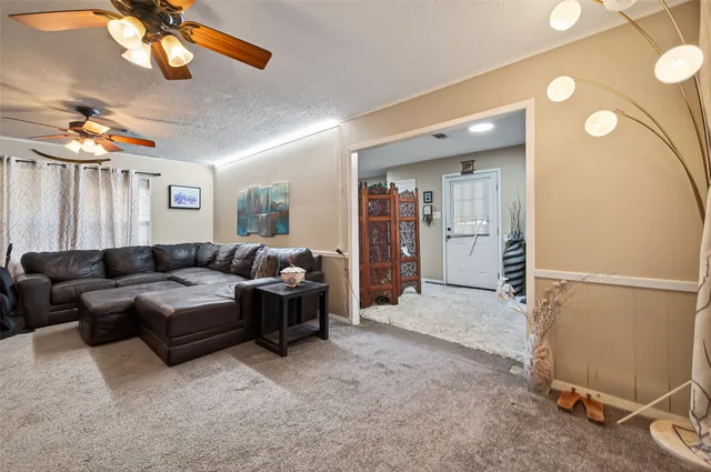 a living room with furniture a chandelier and a window
