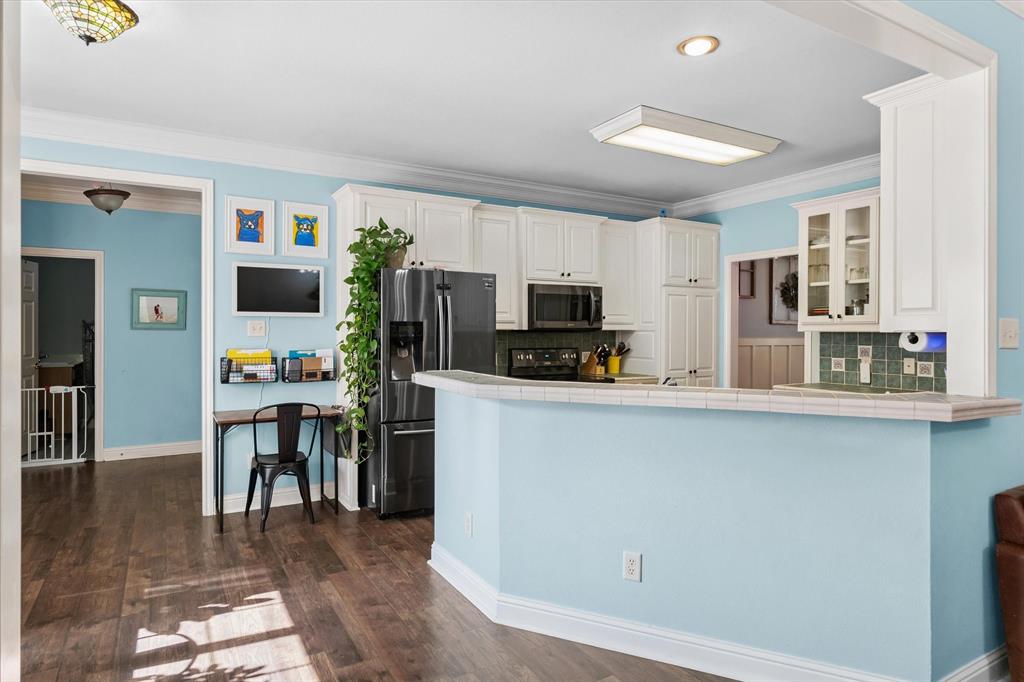 176 County Road 3282 Quitman, TX 75783 - Photo 10 of 35 a kitchen with stainless steel appliances a stove top oven a sink a refrigerator a microwave oven with cabinets and wooden floor