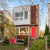 a view of a building with a red door and a porch