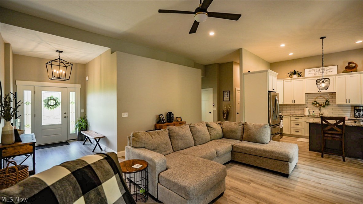 4211 Burgett Road Canfield, OH 44406 - Photo 4 of 17 Living room featuring light wood-type flooring and ceiling fan with notable chandelier
