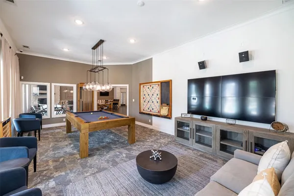 a living room with furniture kitchen view and a wooden floor