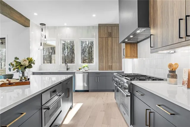 a kitchen with stainless steel appliances granite countertop a sink stove and cabinets