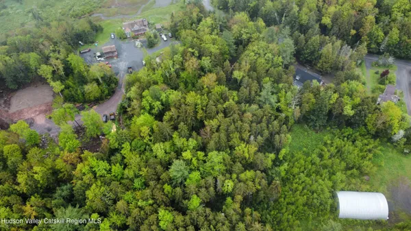 an aerial view of residential house with outdoor space and trees all around