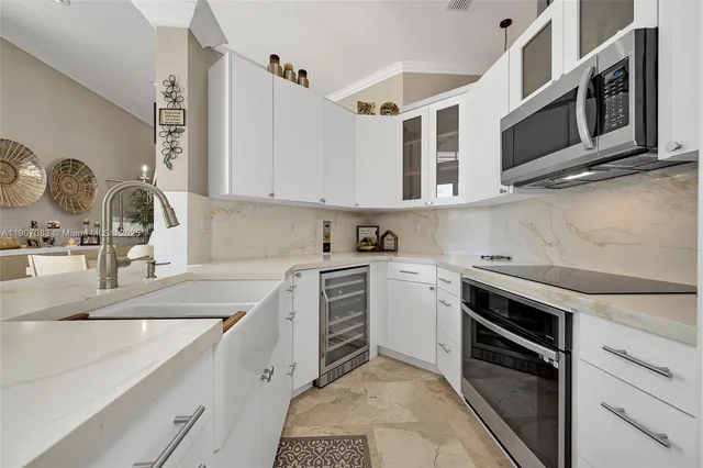 a kitchen with stainless steel appliances kitchen island granite countertop a refrigerator and a stove top oven