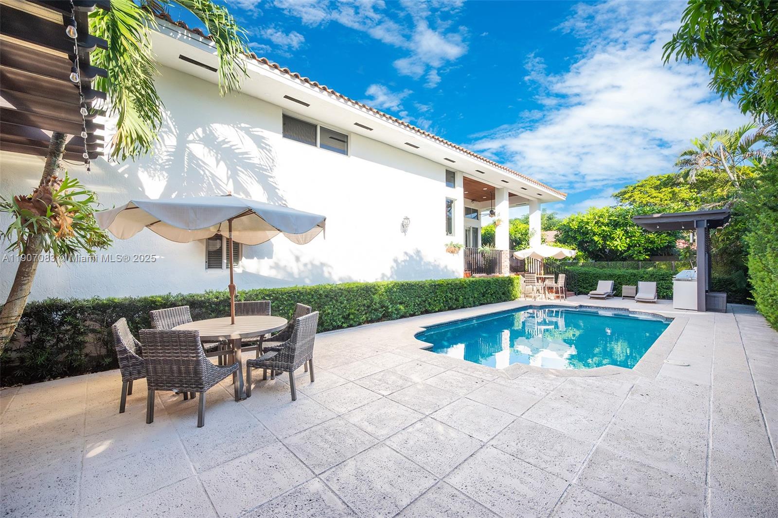 8025 Southwest 91 Avenue Miami, FL 33173 - Photo 42 of 51 a view of a patio with a table and chairs under an umbrella