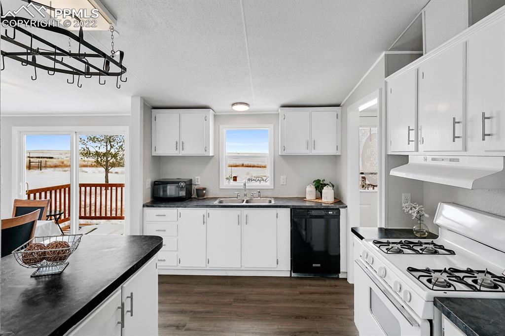 34010 Sanborn Road Yoder, CO 80864 - Photo 13 of 35 a kitchen with granite countertop a sink stove and cabinets