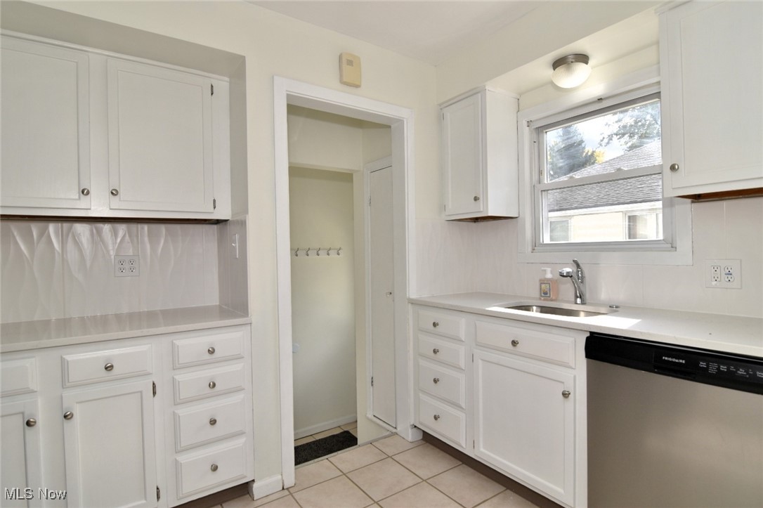1575 Lander Road Cleveland, OH 44124 - Photo 12 of 49 Kitchen featuring dishwasher, white cabinetry, light tile patterned flooring, and backsplash