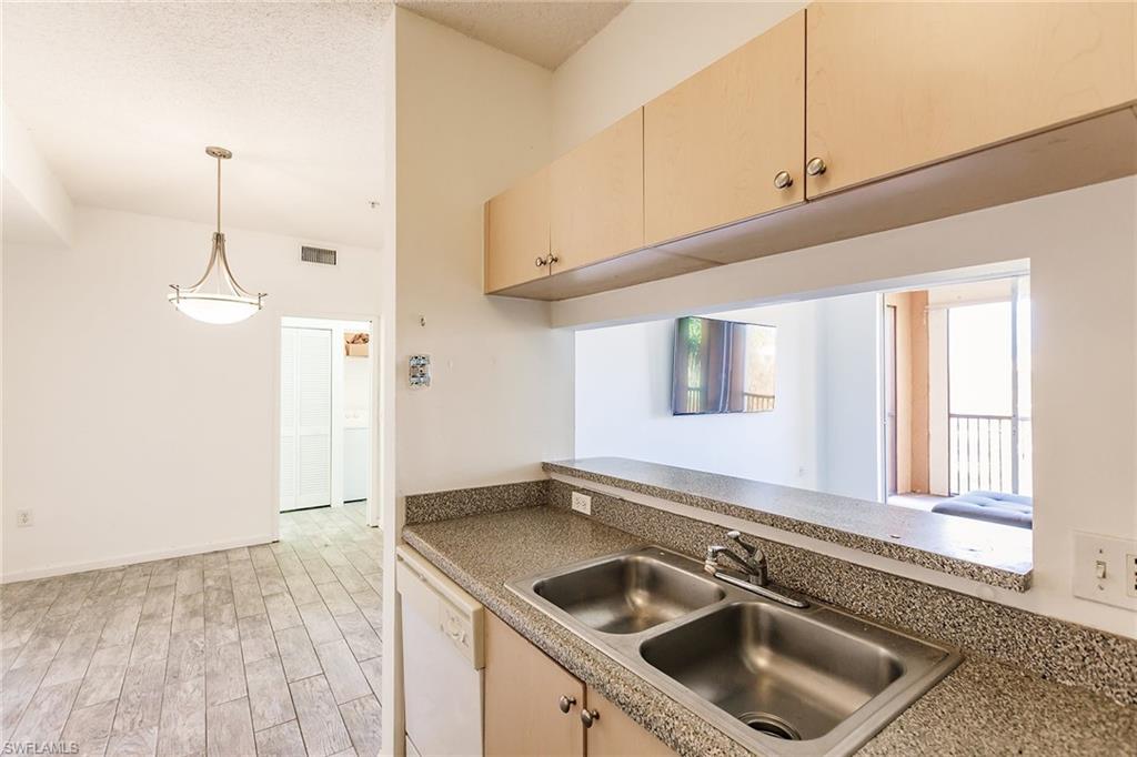 1200 Reserve Way, Unit 302 Naples, FL 34105 - Photo 11 of 12 a kitchen with a sink cabinets and window