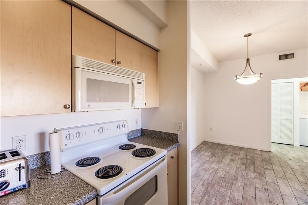 1200 Reserve Way, Unit 302 Naples, FL 34105 - Photo 12 of 12 a kitchen with a stove and a microwave