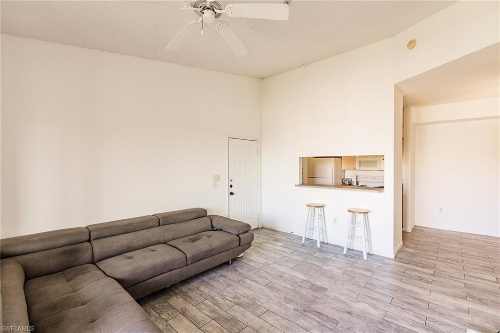 1200 Reserve Way, Unit 302 Naples, FL 34105 - Photo 4 of 12 a living room with furniture and painting on the wall