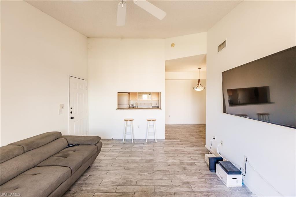 1200 Reserve Way, Unit 302 Naples, FL 34105 - Photo 5 of 12 a living room with furniture and a flat screen tv