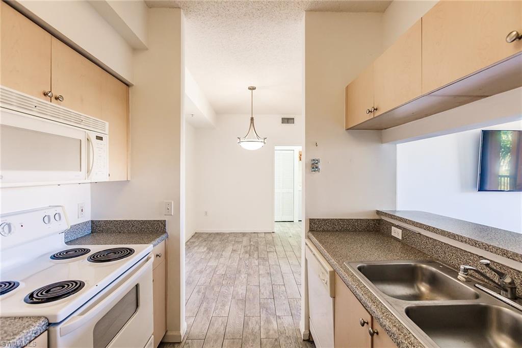 1200 Reserve Way, Unit 302 Naples, FL 34105 - Photo 10 of 12 a kitchen with a stove and a sink