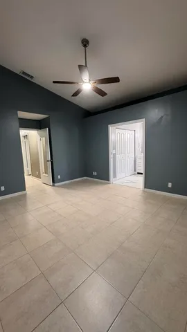 a view of an empty room with a chandelier fan