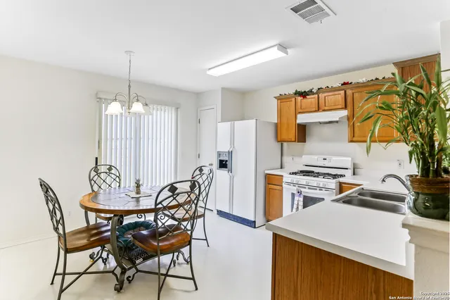 a kitchen with stainless steel appliances a stove a refrigerator and a wooden cabinets