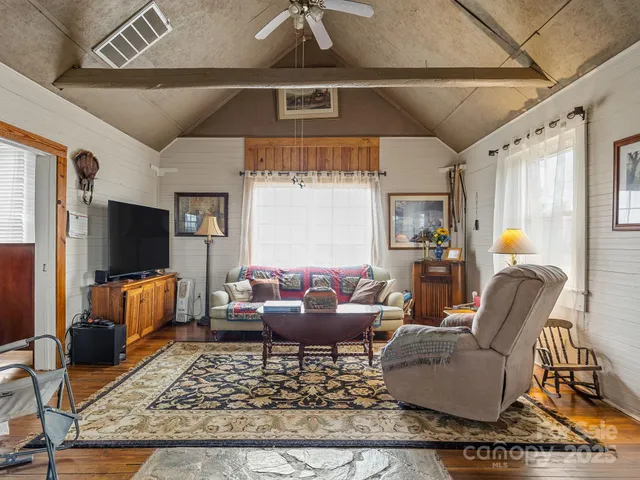 a living room with furniture a rug and a flat screen tv