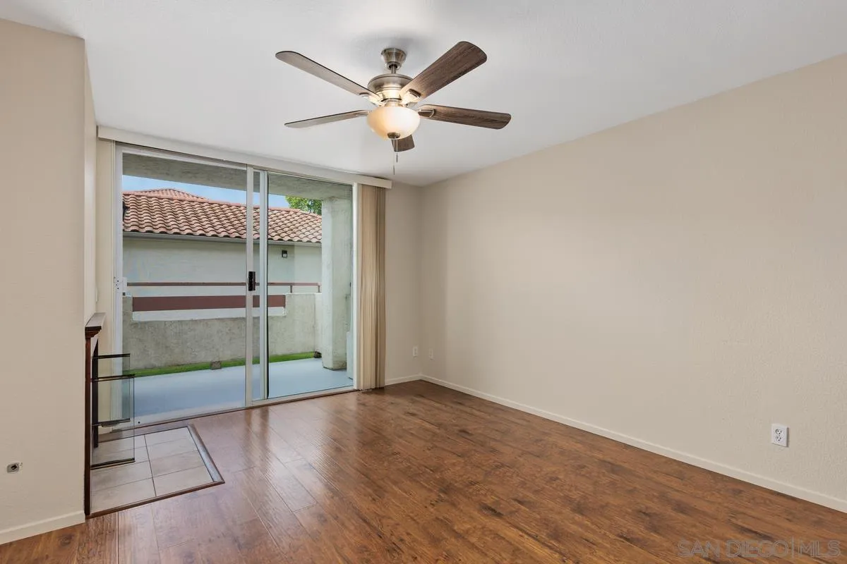 405 Stoney Point Way, Unit 89 Oceanside, CA 92058 - Photo 11 of 32 an empty room with wooden floor fan and windows
