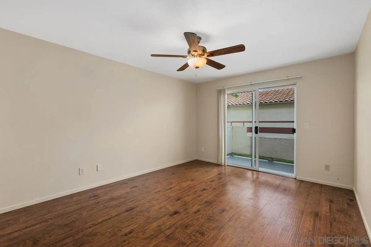 405 Stoney Point Way, Unit 89 Oceanside, CA 92058 - Photo 15 of 32 an empty room with wooden floor closet and ceiling fan