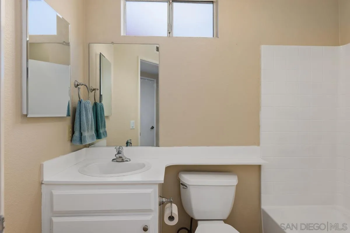 405 Stoney Point Way, Unit 89 Oceanside, CA 92058 - Photo 19 of 32 a bathroom with a toilet sink and mirror