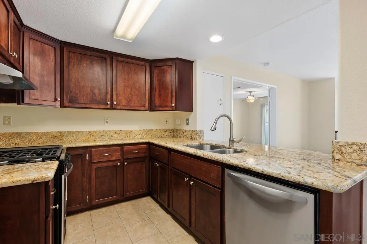 405 Stoney Point Way, Unit 89 Oceanside, CA 92058 - Photo 4 of 32 a kitchen with granite countertop a sink and cabinets
