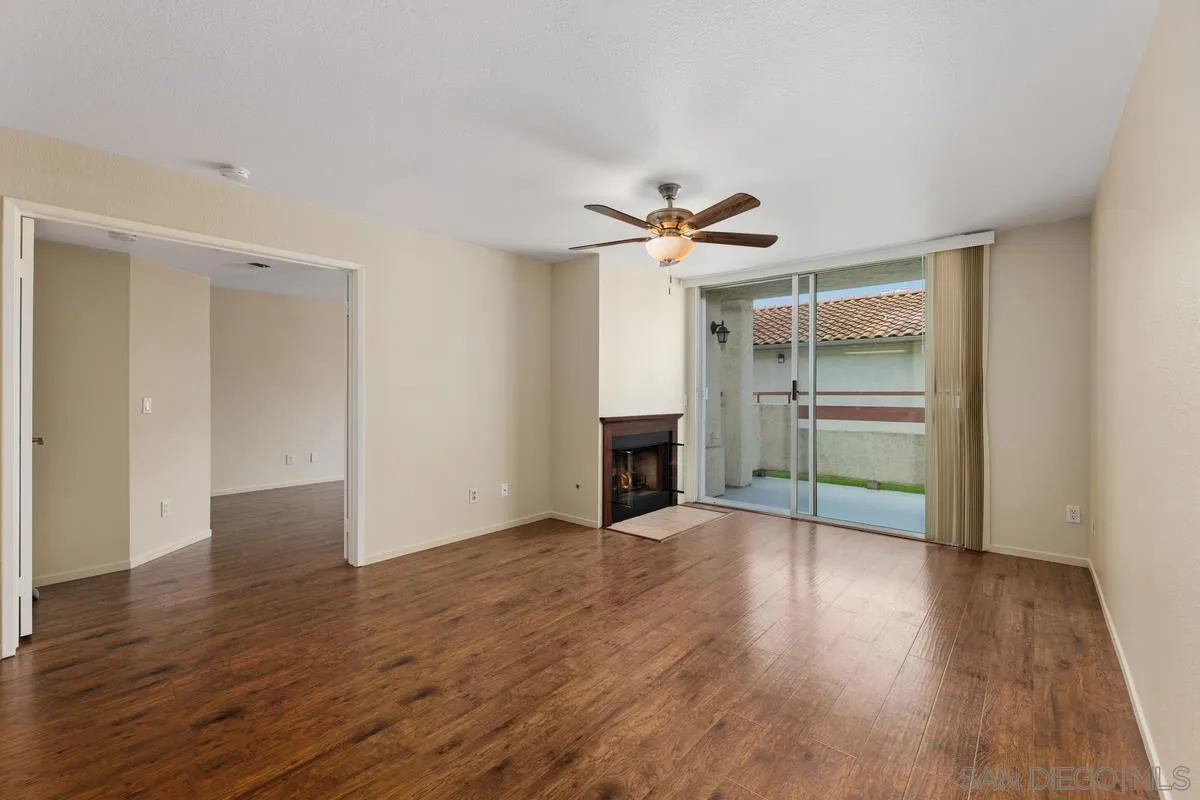 405 Stoney Point Way, Unit 89 Oceanside, CA 92058 - Photo 10 of 32 an empty room with wooden floor and ceiling fan