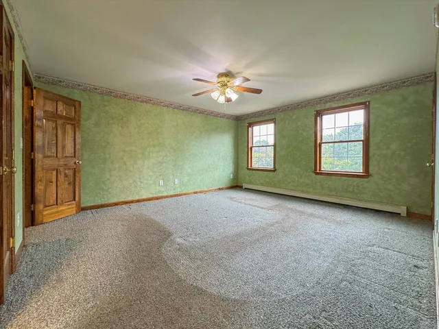an empty room with windows and fan