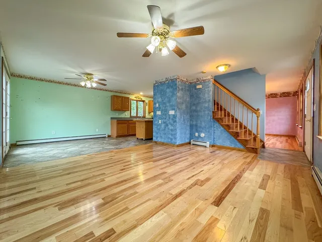 a view of a room with wooden floor and ceiling fan