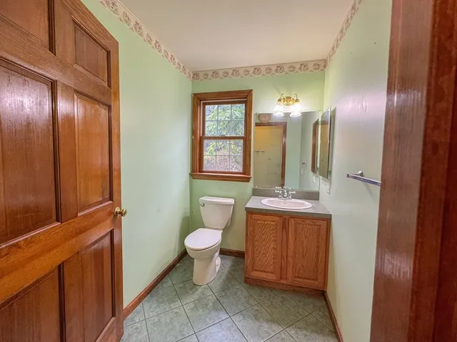 a bathroom with a toilet sink and mirror