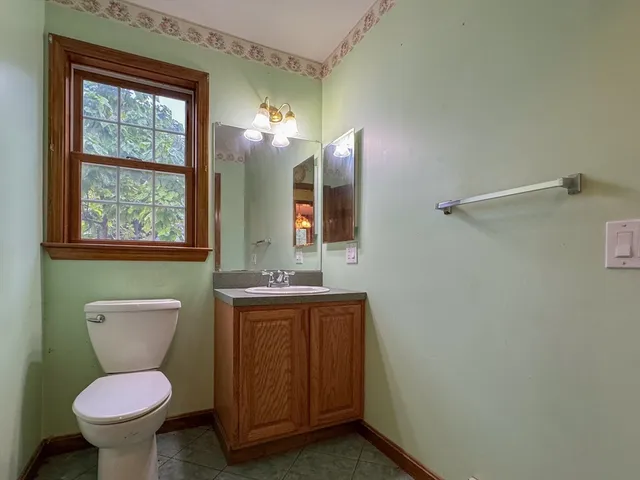 a bathroom with a toilet sink vanity and mirror