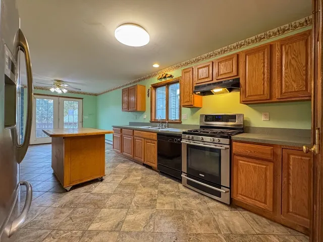 a kitchen with stainless steel appliances granite countertop a stove a sink and a microwave