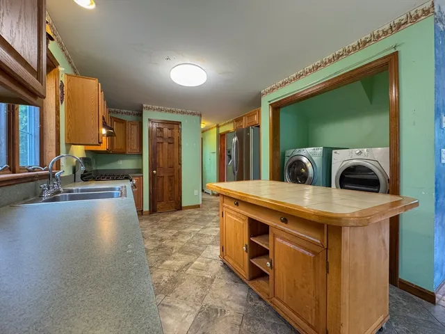 a view of living room with stainless steel appliances granite countertop furniture and a large window
