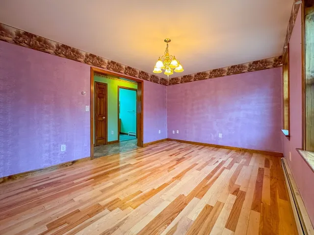 a view of a room with wooden floor a ceiling fan and window