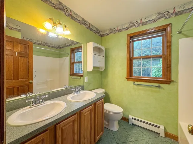 a bathroom with a double vanity sink toilet and a mirror
