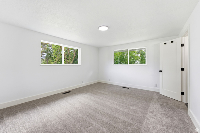 871 Bonita Way Centerville, UT 84014 - Photo 28 of 61 Bright interior space featuring two windows, recessed lighting, neutral carpeting, white baseboards, and a white door with black hardware