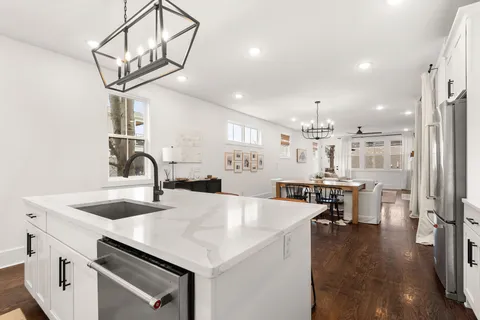 a kitchen with a sink a stove and chairs