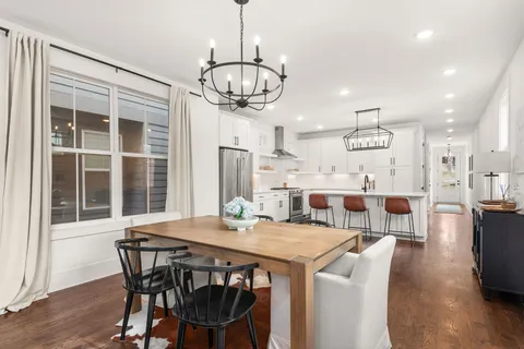 a view of a dining room with furniture wooden floor and chandelier