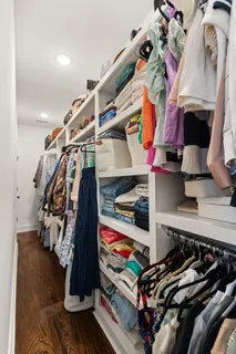 a view of walk in closet with clothes and shoes